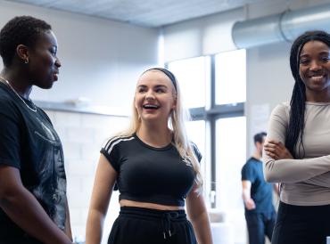 Photo of three smiling students in rehearsals