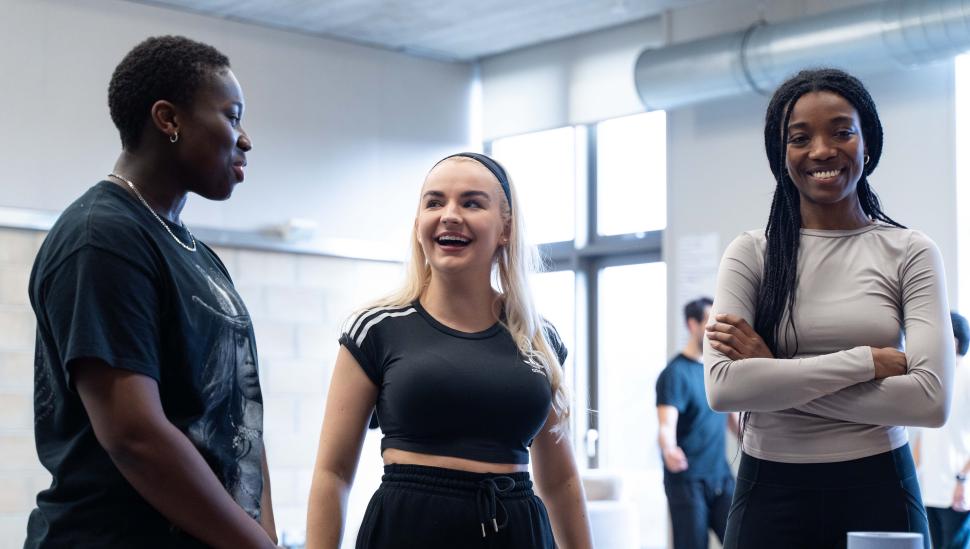Photo of three smiling students in rehearsals
